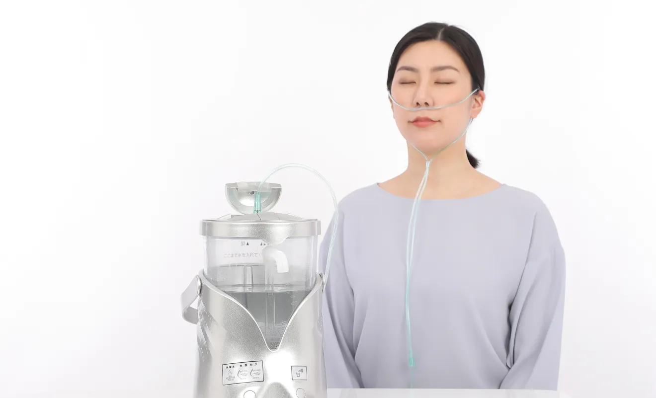 水素ガス吸入チューブを装着し、水素飲水器で水素ガスを吸入する女性